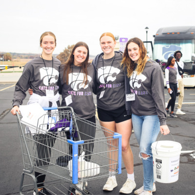 Volunteers collecting food and funds at Cats for Cans football game.