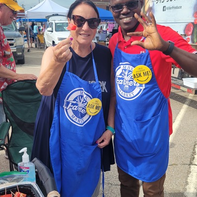 Ambassadors at the Market - Volunteers Distributing Free Vendor Sample to Market Customers