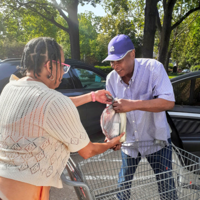 FHBB Partner First Presbyterian volunteer hands food to guest.
