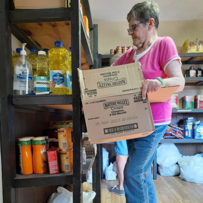 FHBB Partner Grace Baptist volunteer stocks shelf after delivery.