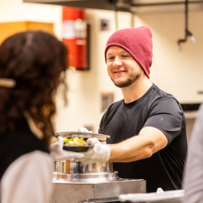 Kitchen volunteer finishes order for Thanksgiving plate.